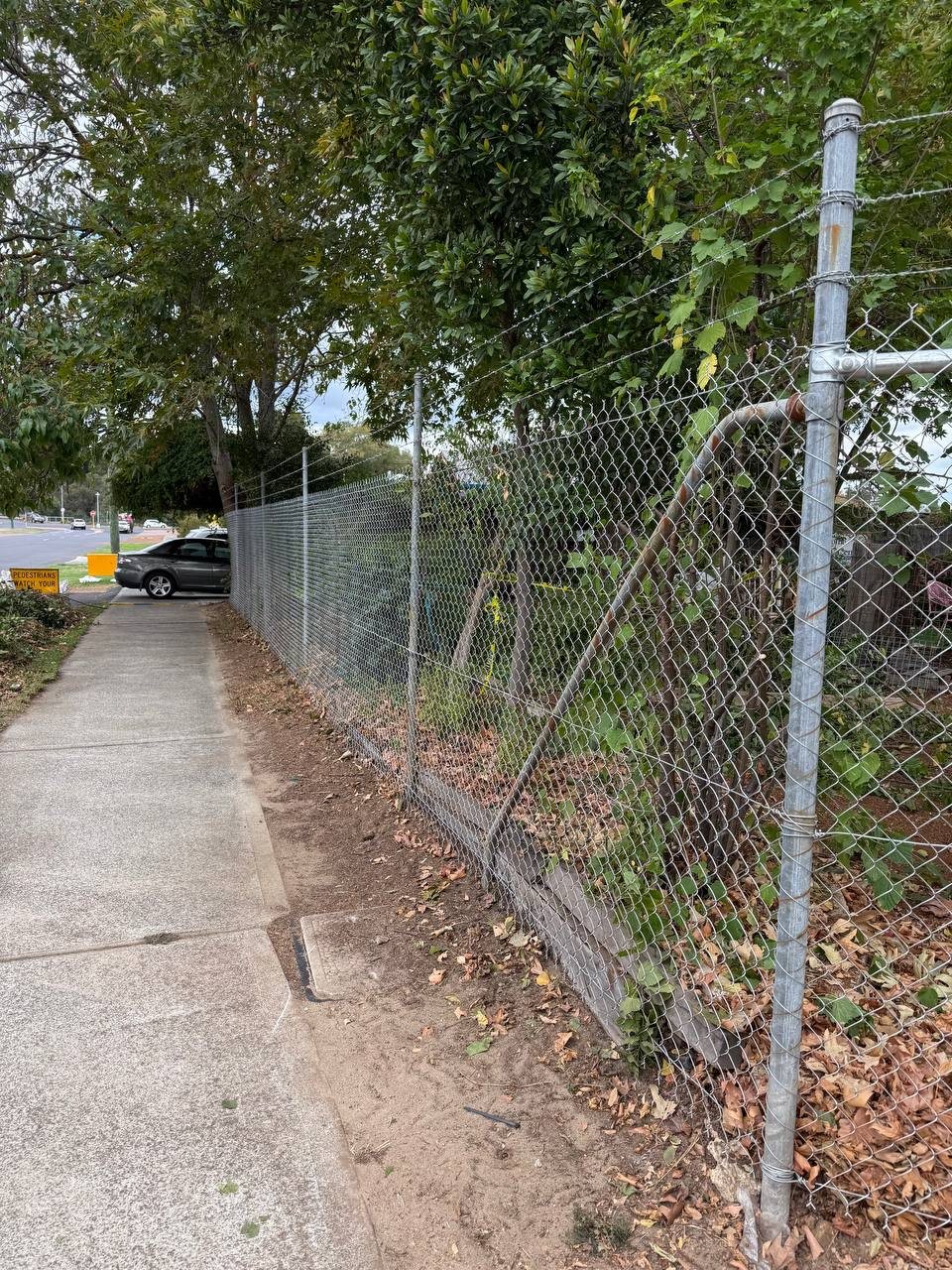 Galvanised chain-link security fence with barbed-wire top