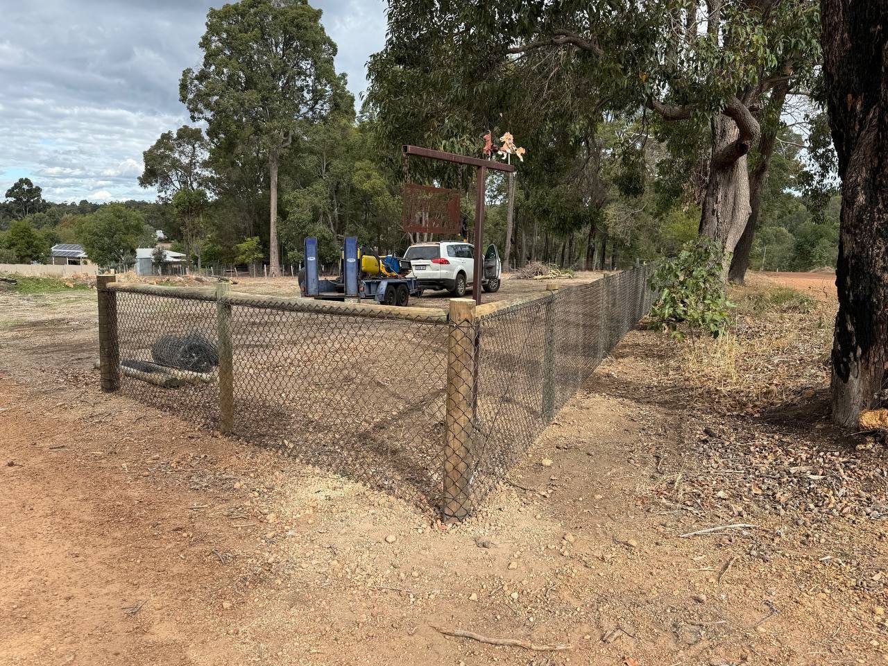 Rural chain-mesh stock fence on timber posts